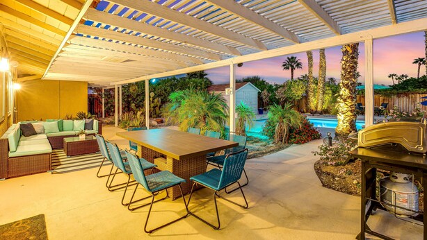An outdoor patio area with a wooden table, chairs, and a sofa. - Upscale private paradise on large dog-friendly lot w/ free EV charger (Palm Springs)