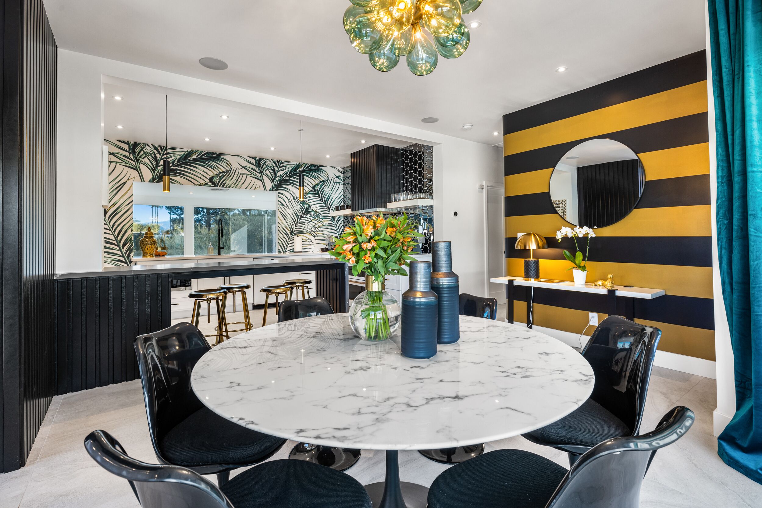 A modern dining area with a marble table, black chairs, and decorative vases.