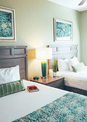 Cozy retreat with a neatly made bed, bedside table, and potted plant.