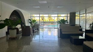 A spacious lobby with a pool view, featuring a modern seating area and large windows. - Beautiful Apartment in Bocagrande  (Cartagena)