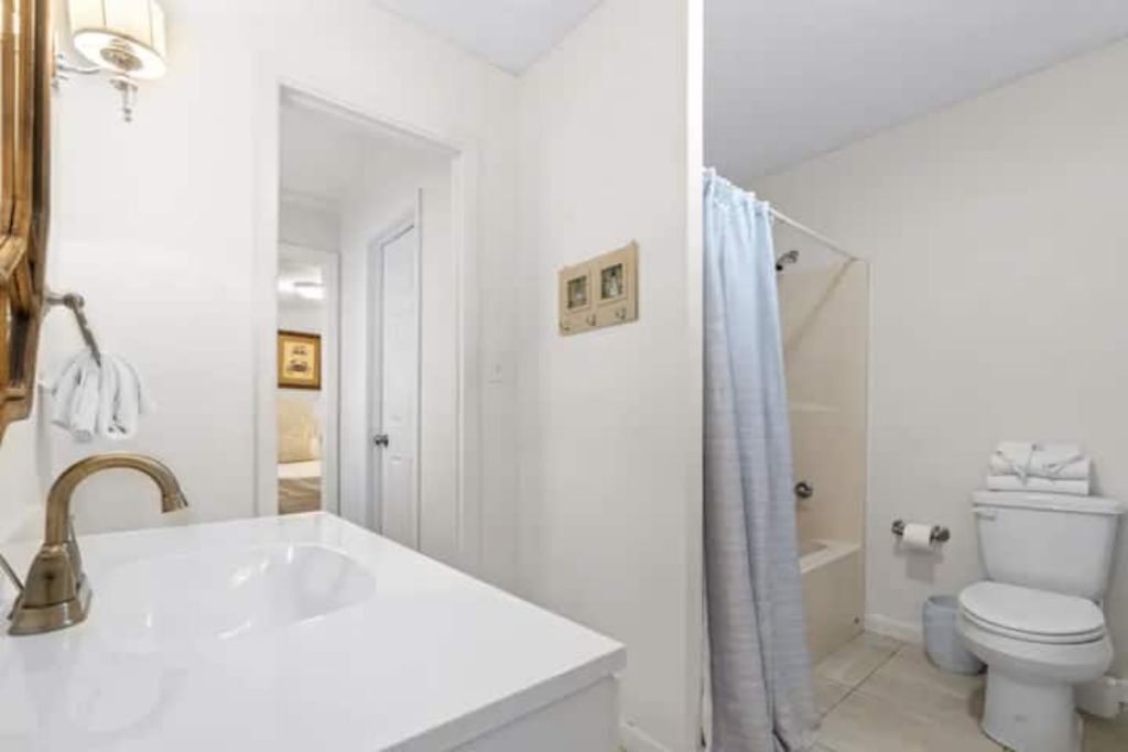 A bathroom with a white sink, a toilet, and a shower area.