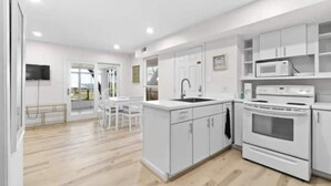 Une cuisine moderne avec des meubles blancs, un four à micro-ondes encastré et un four double.