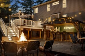 A patio area with a fire pit, outdoor seating, and a covered dining area. - Walk to Top-Rated Restaurants & Trails! 7BR w/HotTub Gazebo & Built-in FirePit! (Purcellville)