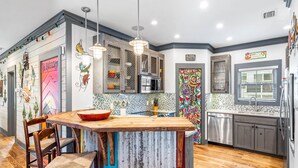 Une cuisine moderne avec un plancher en bois, un îlot central et divers éléments décoratifs.