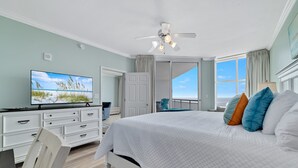 A bedroom with a bed, a television, a ceiling fan, and a view of the outdoors. - Palacio 1703 | Stunning Gulf Views | My Beach Getaways (Pensacola)