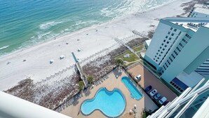 A beachside hotel with a swimming pool, beach access, and a view of the ocean. - Palacio 1703 | Stunning Gulf Views | My Beach Getaways (Pensacola)