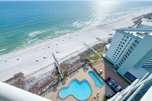 A beachside hotel with a swimming pool, beach access, and a view of the ocean. - Palacio 1703 | Stunning Gulf Views | My Beach Getaways (Pensacola)