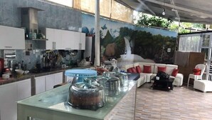 Uma cozinha moderna com uma mesa de vidro, armários brancos e um mural com uma cascata.