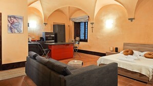 Una habitación con cama, sofá, kitchenette y mesa de comedor.