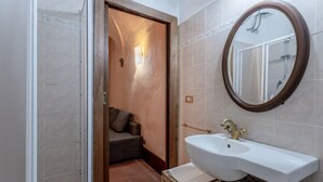 Un baño con lavabo, espejo y ducha.