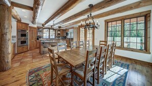 Una cocina amplia con armarios de madera, una isla grande y un comedor con mesa y sillas de madera.