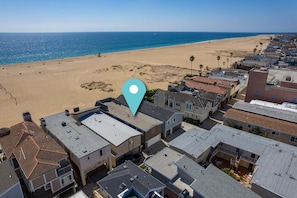 A residential area with houses, a beach, and a clear sky.
