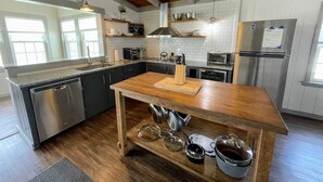 Una cucina moderna con isola in legno, elettrodomestici in acciaio inossidabile e travi a vista.