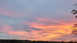 A sunset over a natural landscape with trees and a clear sky. - Primitive Camping⛺️Under the Stars🌠 
5 minutes to Bandera! (Bandera)
