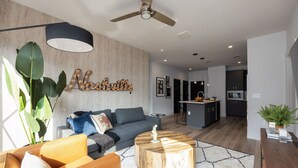 A modern living room with a sofa, coffee table, and a wall-mounted light fixture.