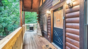 Une cabane en bois dotée d’une terrasse, d’un paillasson et d’une enseigne indiquant un restaurant servant des hamburgers et des plats grillés.