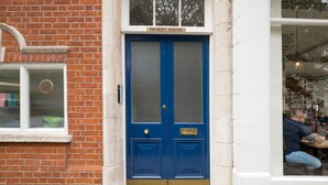 A blue double door with a sign above reading "REGENT HOUSE". - Serene St Johns Wood 2BR, nr Park & Universities, by Blueground (London)