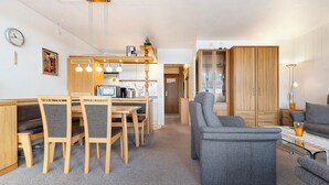 Un salon moderne avec un coin repas, des meubles en bois et un canapé.