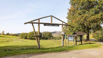 A rural signpost with 'Ebersberg - Loipe' written on it, a gravel path, and a bench.