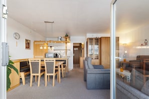 En moderne stue med spiseplads, sofa og fjernsyn.