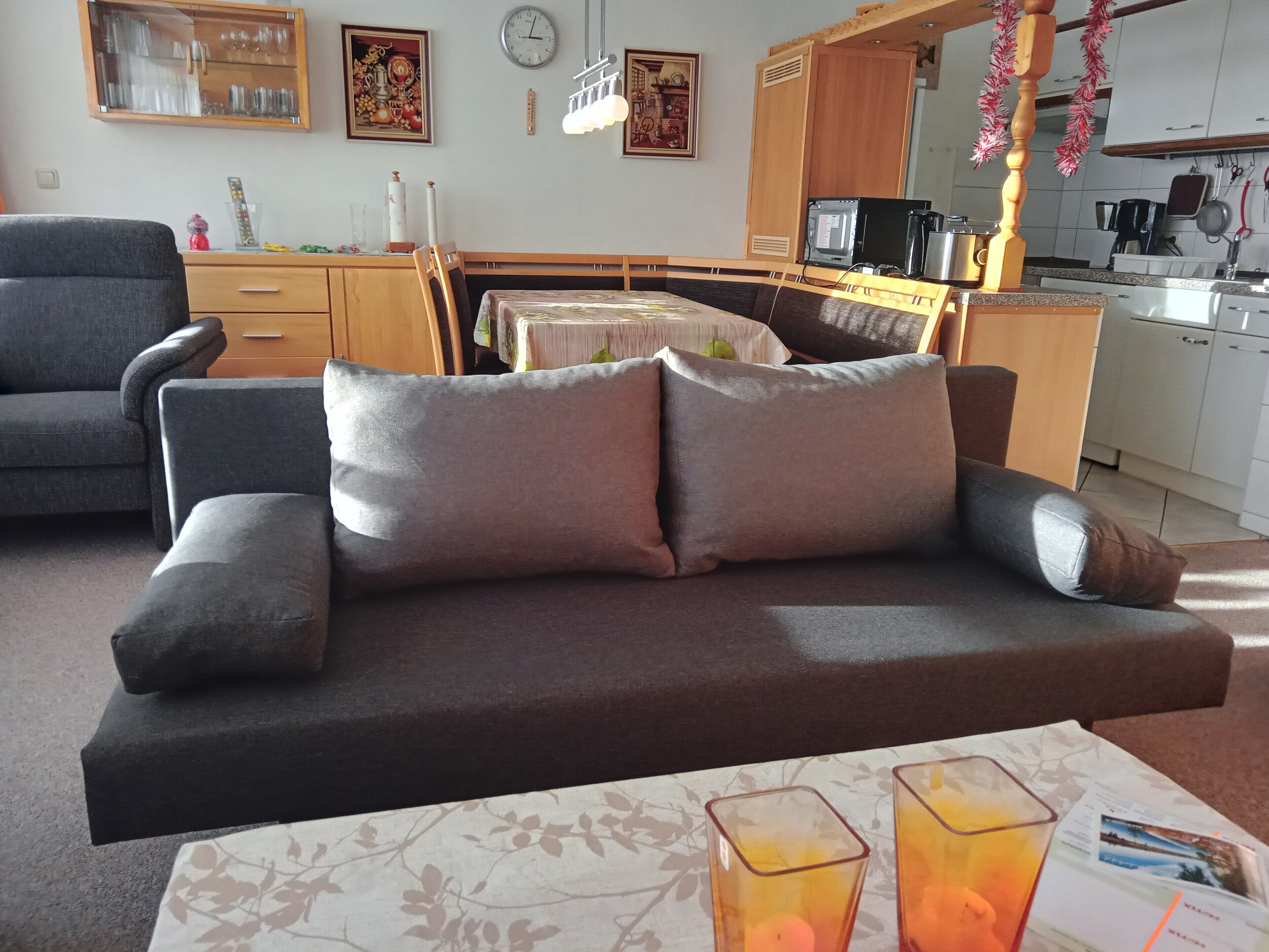 Una sala de estar con sofá, una mesa de comedor y una zona de cocina.