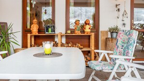 Un comedor con una mesa, sillas y un vaso de jugo de naranja.
