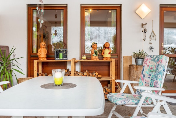 A dining area with a table, chairs, and a glass of orange juice.