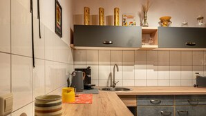 Una cocina moderna con encimera de madera, cafetera, fregadero y muebles empotrados.