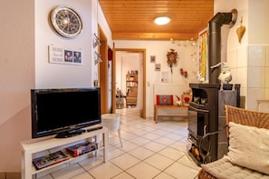 A cozy living room with a television, fireplace, and a bookshelf.