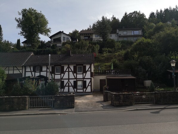 A traditional half-timbered house with a gated driveway and a garage.