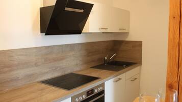 A modern kitchen with a built-in oven, a sink, and wooden countertops.