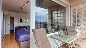 A modern bedroom with a bed, a glass table, and a chair. - Holiday Apartment "Comfort" with Shared Garden, Balcony & Wi-Fi (Brilon)