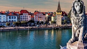 A statue of a lion on a pedestal by a waterfront with buildings and boats in the background. - Apartment 'Appartement S2' with Wi-Fi (Lindau am Bodensee)