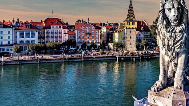 A lion statue by a waterfront with buildings in the background. - Apartment 'Ferienwohnung S6' with Wi-Fi (Lindau am Bodensee)