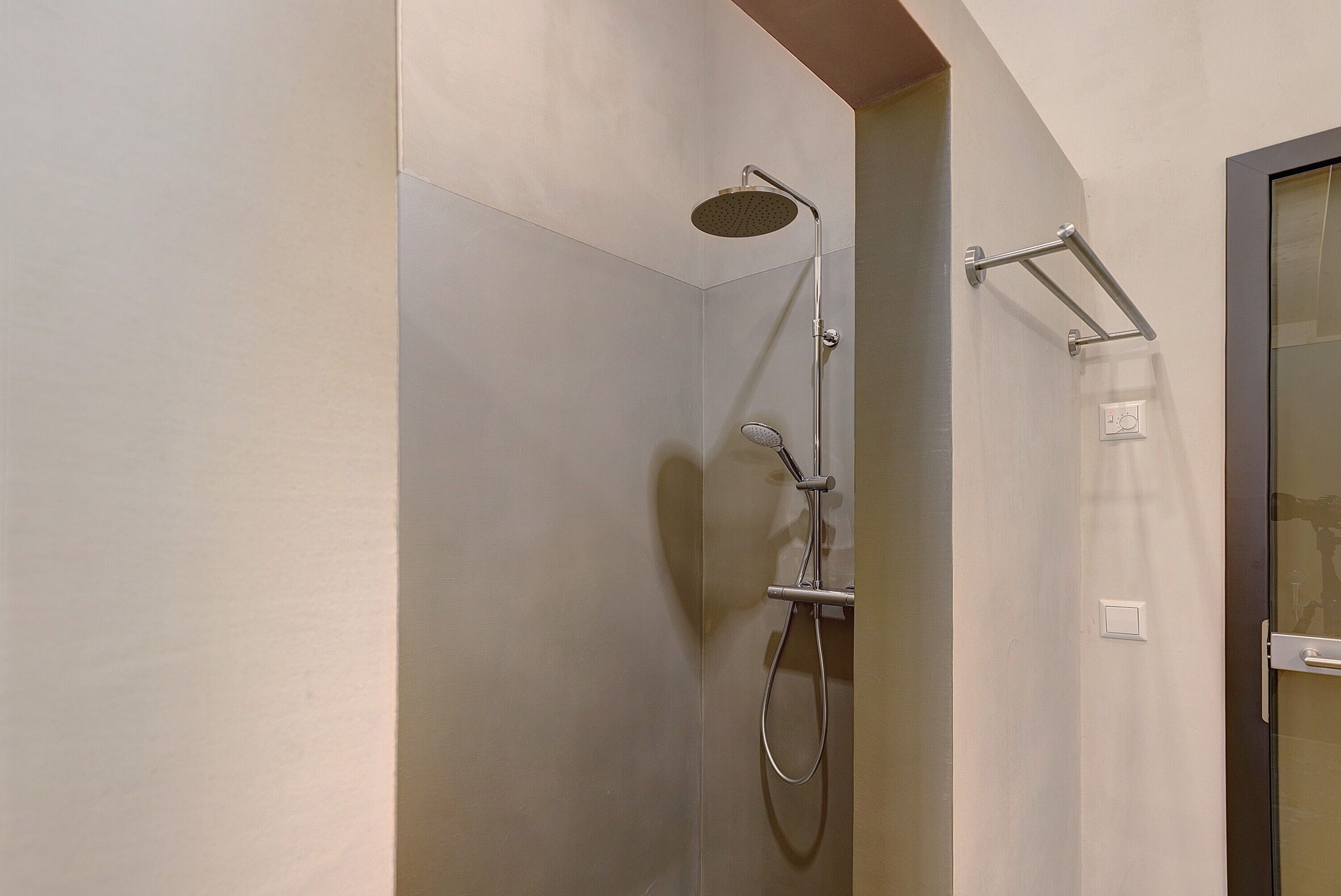 Eine Dusche mit Handbrause und Wandarmatur.
