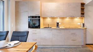 A modern kitchen with a built-in oven, a sink, and a wooden countertop.