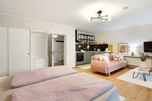 Un appartement moderne comprenant un coin cuisine, un canapé, un lit et un espace repas.