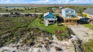 Une propriété située en bord de mer, comprenant une maison principale, une maison d’hôtes et une terrasse couverte.