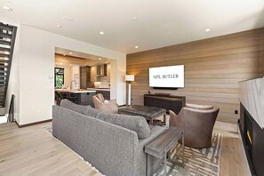 Un salon moderne avec un canapé, une table basse et un téléviseur fixé au mur.