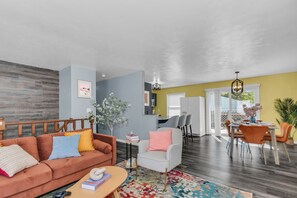 Open concept area showing living room, dining, and bar seating in the kitchen