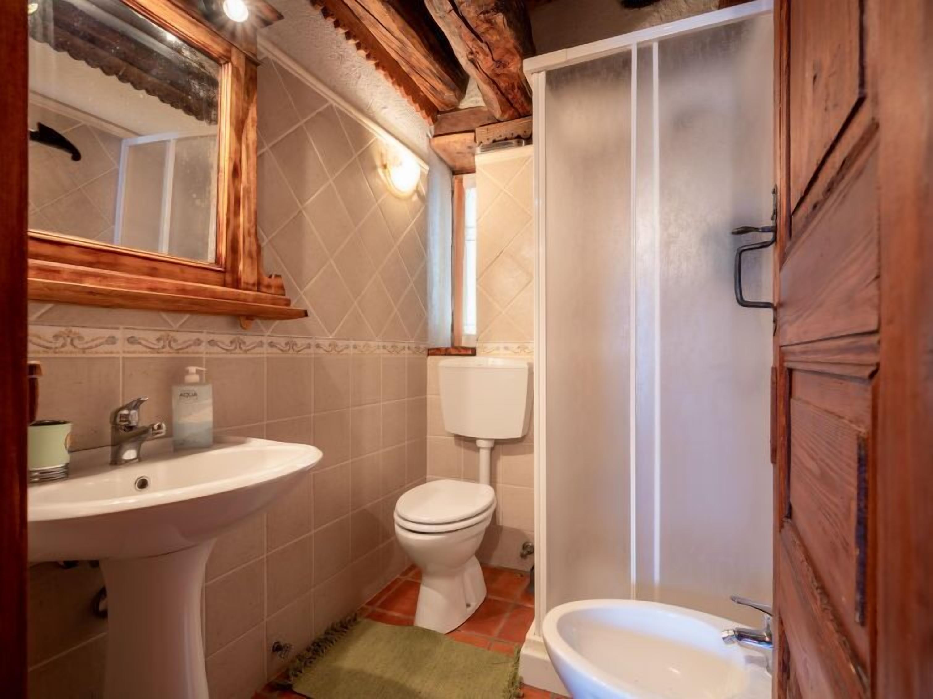 A bathroom with a sink, toilet, and shower.