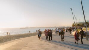 A boardwalk with people walking and cycling, overlooking a beach and water. - Bright 3BR 3 Level Townhouse Port Melbourne (Port Melbourne)