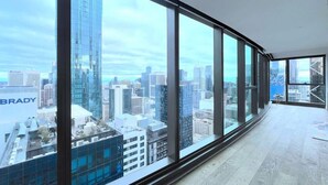 A modern hotel room with large floor-to-ceiling windows offering a cityscape view. - LV42 High-Rise Condo CBD Panoramic City View (Melbourne)
