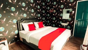 Una cama con ropa de cama blanca y roja, una mesita de noche pequeña, un espejo sobre la cama y una puerta verde.