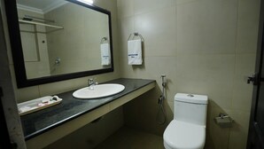 Un baño pequeño con un lavabo blanco, un espejo, un inodoro y una ducha.