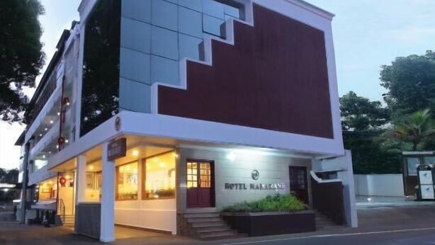 Un hotel moderno con una escalera destacada, una entrada bien iluminada y un letrero con el nombre visible.