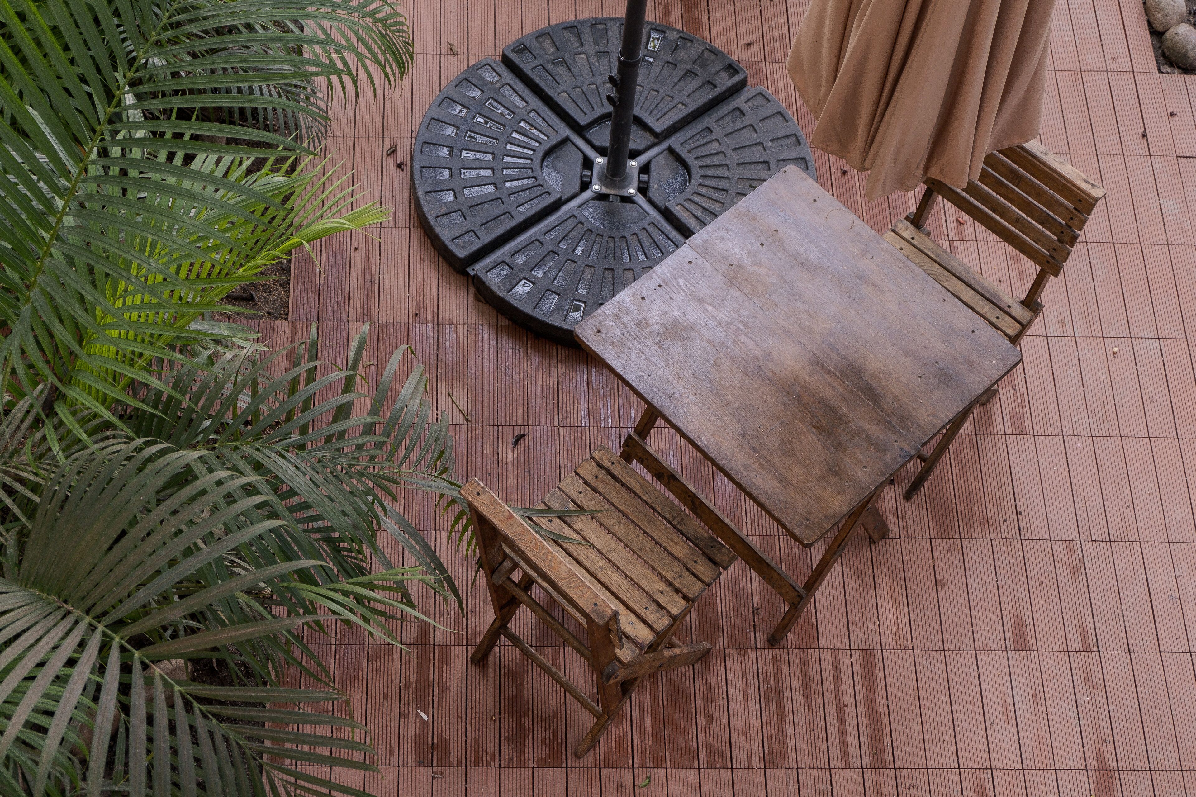 Une table ronde avec un pied en métal noir et quatre chaises en bois.
