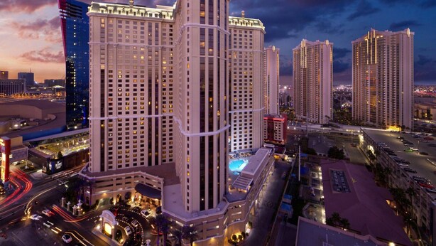 A high-rise hotel with multiple floors, a central courtyard, and a pool.
