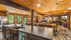 A spacious kitchen with a large island, stainless steel appliances, and a fireplace.