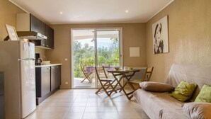 Une cuisine moderne dotée d’un four encastré et d’un coin repas avec une table et des chaises.